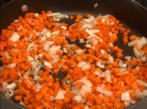 Carrots, onion and garlic saute in a pan