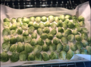 Brussels sprouts cut in half on parchment paper on a baking tray