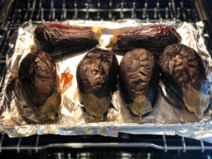 Roasted eggplants out of the oven on a baking sheet
