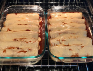 rolled enchiladas coated with red sauce and cheese sauce