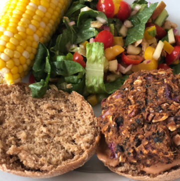 Burger plate with corn on the cob and summer salad