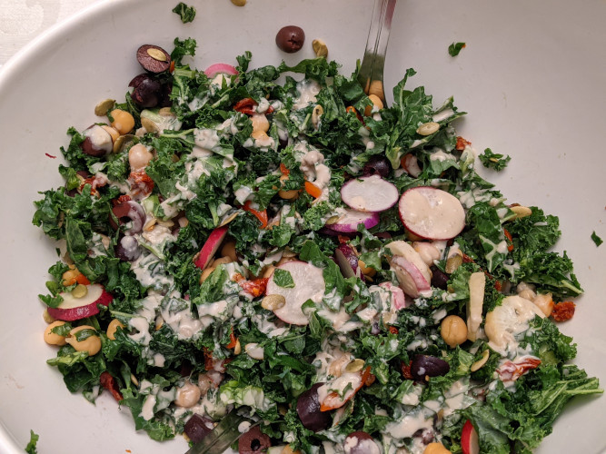 Mediterranean kale salad in white bowl