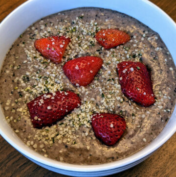 Oatmeal smoothie bowl with strawberries and hemp seeds as topings