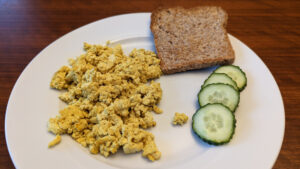 scrambled tofu with cucumber and toast on a plate