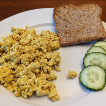 scrambled tofu with cucumber and toast on a plate