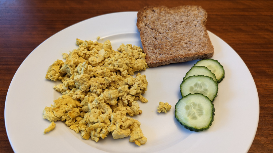 scrambled tofu with cucumber and toast on a plate